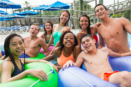Teens swimming at pool with inner tubes 
